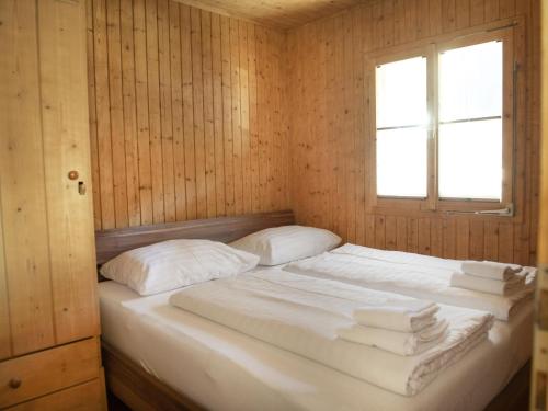 Ce lit se trouve dans une chambre en bois dotée d'une fenêtre. dans l'établissement Ferienhaus mit Weitblick, à Pill