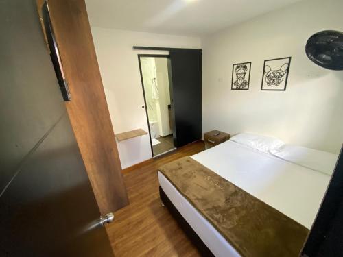 um quarto com uma cama e piso em madeira em Bramasole Hotel Boutique em Bogotá