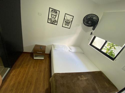 a small room with a bed and a table at Bramasole Hotel Boutique in Bogotá