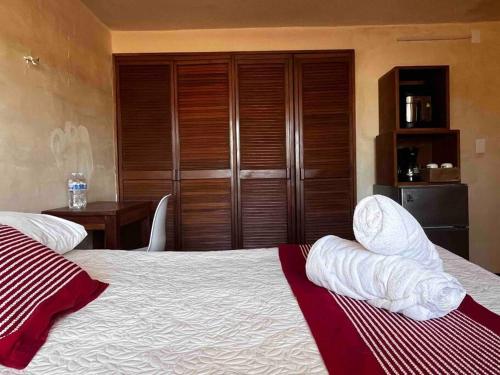een slaapkamer met een bed met witte kussens en een tafel bij Suite 5 -Terraza Vista Gran Parque de la Plancha in Mérida