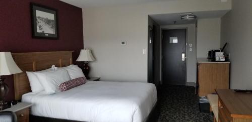 a hotel room with a bed and a desk and a door at The Royal Anne Hotel in Kelowna