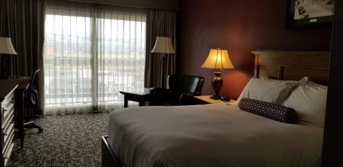 a hotel room with a bed and a chair and a window at The Royal Anne Hotel in Kelowna