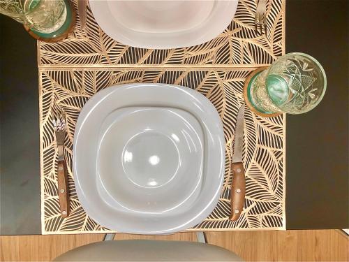 um prato branco sentado numa mesa com dois copos em Alquiler por dia "Como en Casa" Caseros, cerca de Palomar y Hurlingham em Caseros