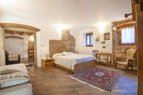 1 dormitorio con cama y pared de piedra en Dimora Laura Romantico con stufa a legna, en SantʼAmbrogio di Valpolicella