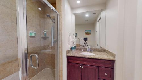 een badkamer met 2 wastafels en een douche met een glazen deur bij LV002 Secluded Downstairs Legacy Villas Studio in La Quinta