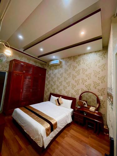 a bedroom with a bed and a table with a phone at HOTEL MINH LÂM 2 in Pleiku