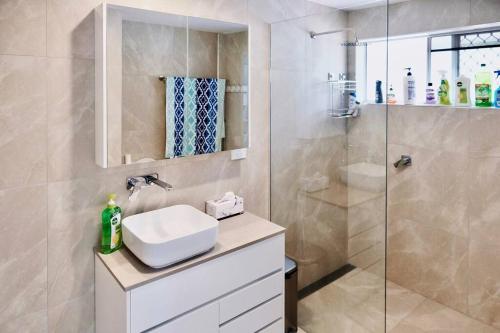 uma casa de banho com um lavatório e um chuveiro em Fully renovated 3 bedroom house & Free Parking em Gold Coast