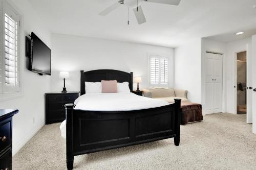 a bedroom with a black bed and a television at Fantastic bayside vacation home - WiFi, central AC, patio, private washer & dryer in San Diego