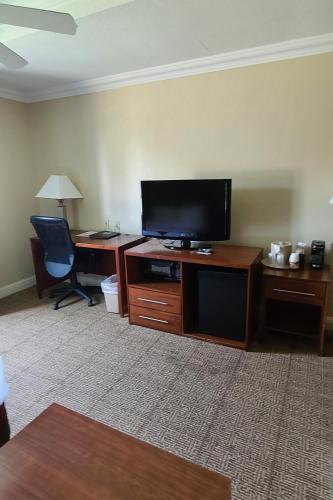 a living room with a flat screen tv and a desk at SAMIR Stay at NW Expressway in Oklahoma City