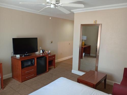 オクラホマシティにあるSAMIR Stay at NW Expresswayのベッド1台、薄型テレビが備わるホテルルームです。