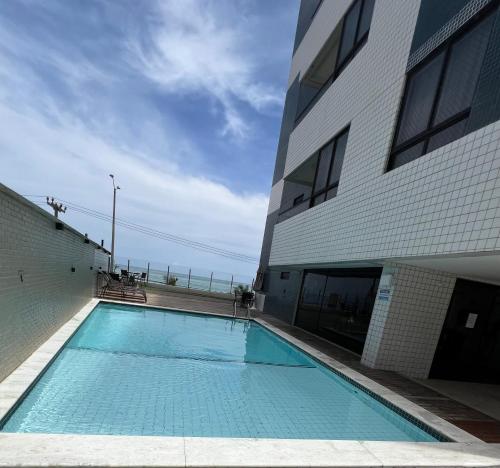 una gran piscina azul junto a un edificio en Seu lugar em Natal, en Natal