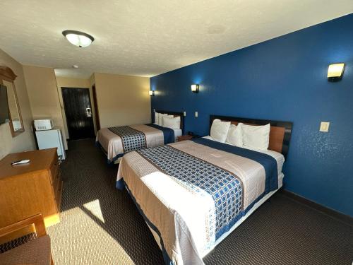 a hotel room with two beds and a blue wall at Eco-Lux Inn Norfolk in Norfolk
