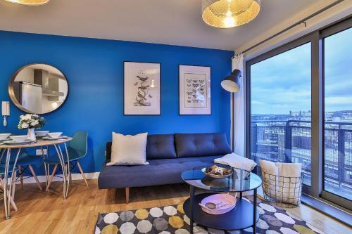 een blauwe woonkamer met een bank en een tafel bij Skyview Apartment by Noknokstay - City centre with Parking - Group, Family, Business in Sheffield