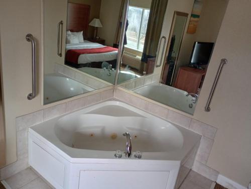 a bathroom with a tub and a large mirror at SAMIR Stay at NW Expressway in Oklahoma City