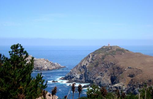 an island in the ocean with a lighthouse on it at Casona Pretton in Valparaíso