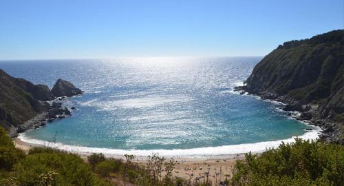 a beach with people on the sand and the ocean at Casona Pretton in Valparaíso