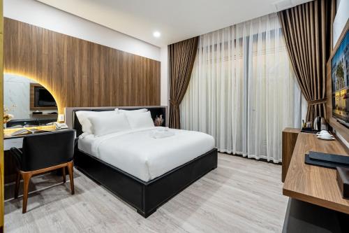a hotel room with a bed and a desk at VIN HOTEL in Vĩnh Long