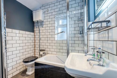 エディンバラにあるNEWLY REFURBISHED QUIET 3 BEDROOM EDINBURGH APARTMENT BY HIGH STREET, TRAMS and BUSESのバスルーム(シンク、バスタブ、トイレ付)