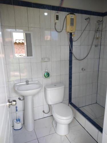 a bathroom with a toilet and a shower and a sink at Casa con jardín y vista a las montañas Pisac in Pisac