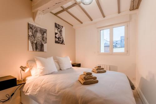 une chambre avec un lit blanc avec des serviettes dessus dans l'établissement Villa Caron - Appartements haut de gamme avec chambre hyper centre, à Rouen
