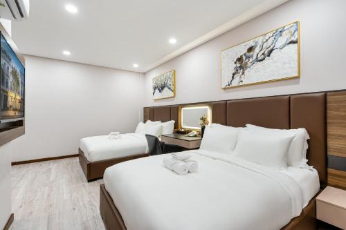 a hotel room with two beds and a tv at VIN HOTEL in Vĩnh Long