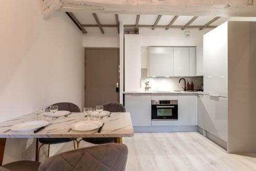 une cuisine et une salle à manger avec une table et des chaises dans l'établissement Villa Caron - Appartements haut de gamme avec chambre hyper centre, à Rouen