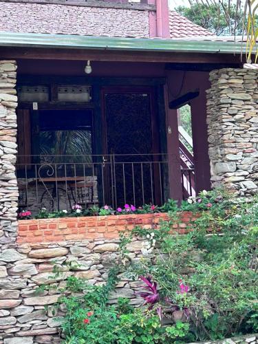a front door of a brick house with flowers at Pousada Serra Morena in Serra do Cipo