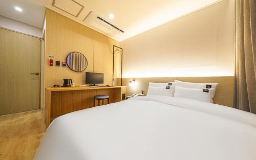a hotel room with a bed and a desk at Browndot Gangneung Station in Gangneung
