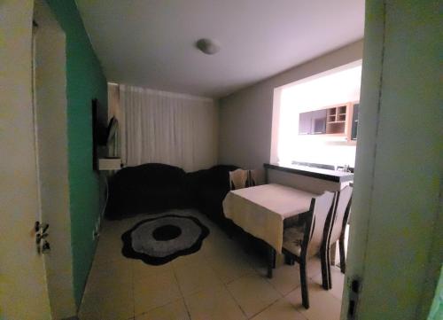 a small room with a table and a couch at Apartamento no val in Valparaíso de Goiás