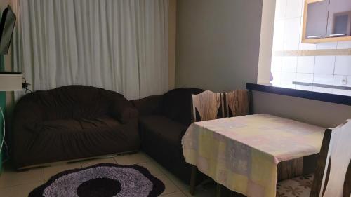 a living room with a couch and a table at Apartamento no val in Valparaíso de Goiás