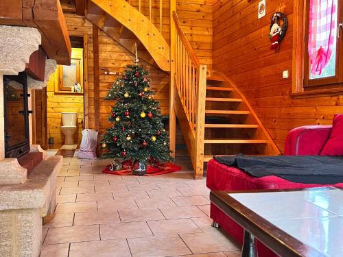 a christmas tree in a room with a staircase at Chalet confortable avec cheminée à Taintrux - FR-1-589-222 in Taintrux
