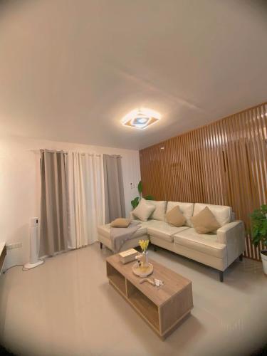 a living room with a couch and a coffee table at Time To Sleep - Casa Ala Una in Butuan