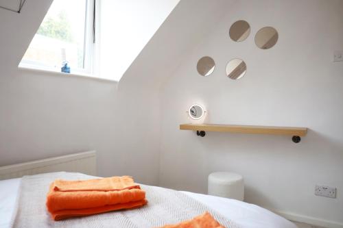 Una toalla naranja sentada en una cama en una habitación en Private Parking & Pillow Paradice & With RR Housing, en Leamington Spa