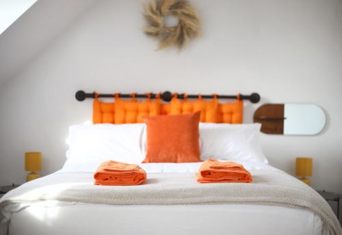 Una cama con dos toallas naranjas encima. en Private Parking & Pillow Paradice & With RR Housing, en Leamington Spa
