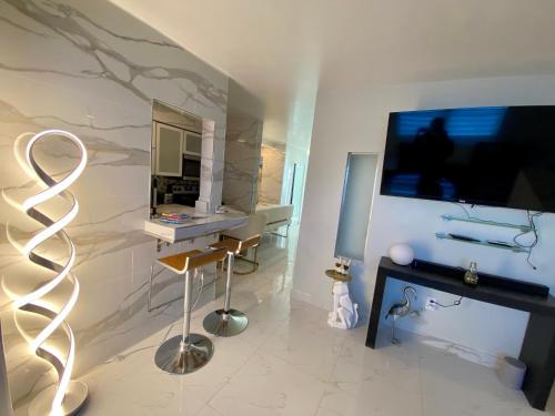 uma sala de estar com uma televisão e uma mesa com um banco em Luxurious remodeled direct Waterfront apartment with Miami skyline view and outdoor terrace Free parking 5min drive to Miami Beach em Miami Beach