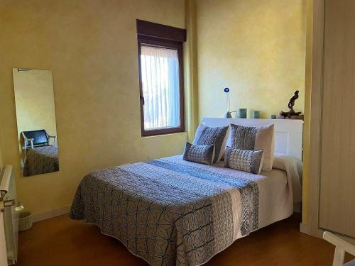 1 dormitorio con cama con almohadas y ventana en One bedroom property with wifi at Tubilla del Lago, en Tubilla del Lago