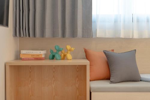 a room with a bed and a shelf with toys on it at Browndot Gangneung Station in Gangneung