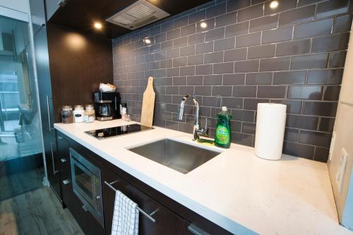 a kitchen with a sink and a counter top at Modern 1 bedroom sleeps 3 Yorkville STK in Toronto