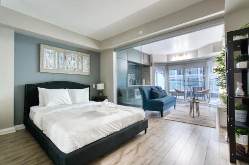 1 dormitorio con 1 cama grande y 1 silla azul en Modern 1 bedroom sleeps 3 Yorkville STK en Toronto