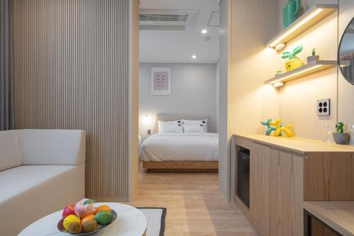 a bedroom with a bed and a table with a bowl of fruit at Browndot Gangneung Station in Gangneung