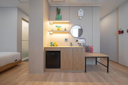 a bathroom with a vanity with a sink and a mirror at Browndot Gangneung Station in Gangneung