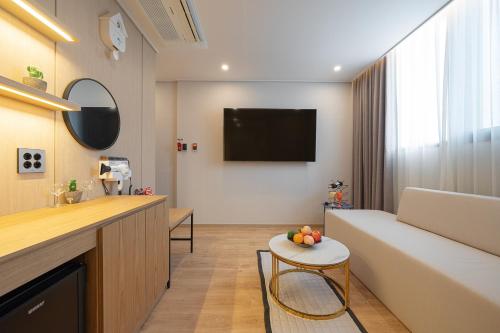 a living room with a couch and a table at Browndot Gangneung Station in Gangneung