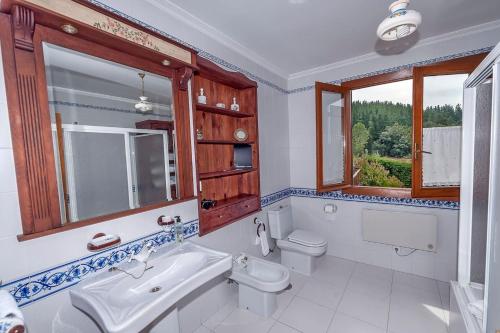 San Juan de la Mata的住宿－3 bedrooms chalet with shared pool terrace and wifi at San Juan de la Mata，一间带水槽和卫生间的浴室以及窗户。