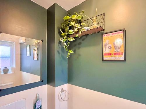 a bathroom with a mirror and a plant on the wall at Payler House Sheffield-WiFi -Large Parking Space-cozy 4 bedrooms in Sheffield