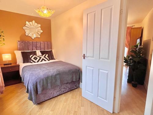 a bedroom with a bed and a clock on the wall at Noknokstay-Payler House-cozy 4 bedrooms in Sheffield