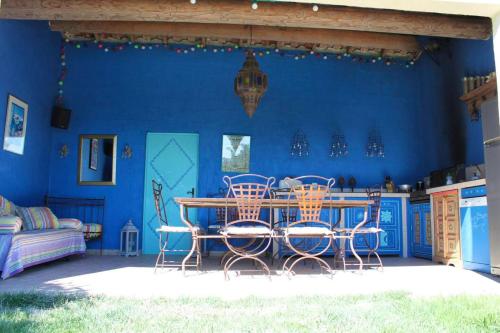 une chambre bleue avec une table et des chaises dans l'établissement Villa élégante à Villelaure + Clim, à Villelaure