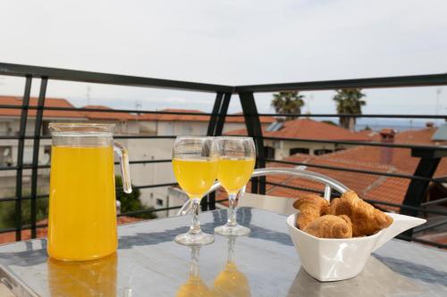 twee glazen sinaasappelsap en brood op een tafel bij Iasmos - Yiasemi in Pefkochori