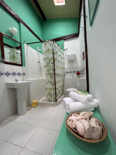 een badkamer met een wastafel en een douche met handdoeken bij Pousada Marina de Boipeba in Ilha de Boipeba