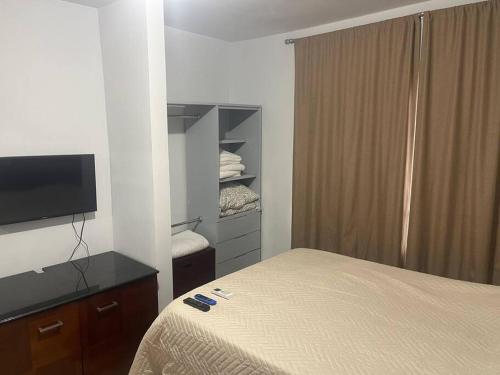 a hotel room with a bed and a television at Departamento Tranquilo NL in Monterrey