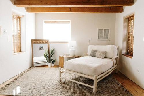 Group Getaway: Serene Adobe Retreat 4-11 guests في ألباكيركي: غرفة نوم بسرير وكرسي في غرفة